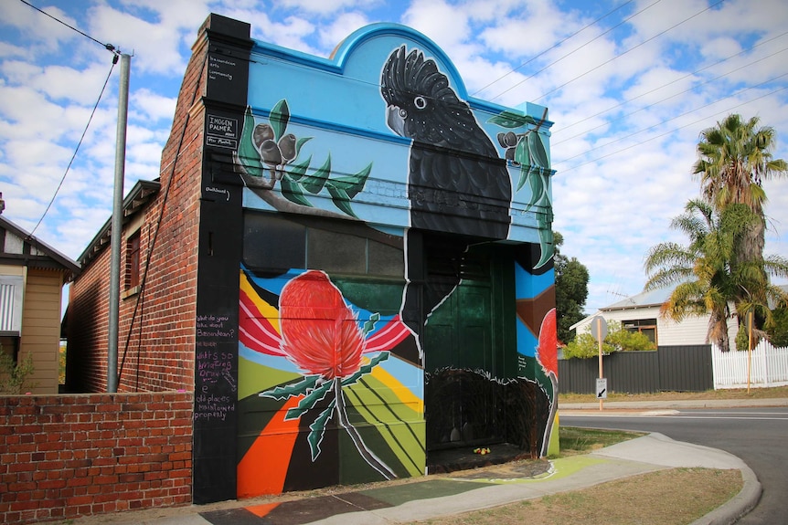 An art mural on a street corner building