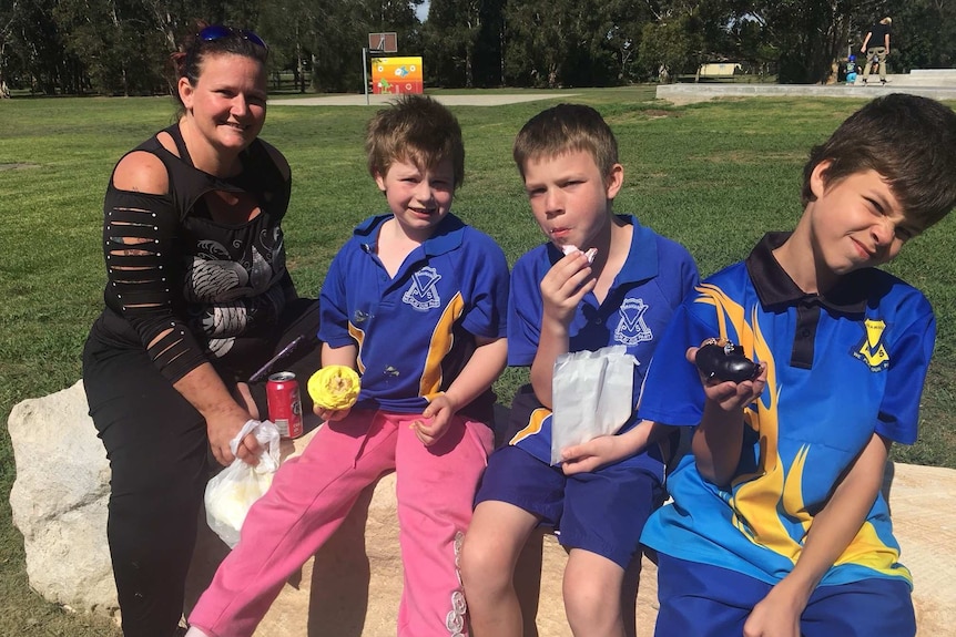 Suzie short sits at a park with her three primary school aged boys