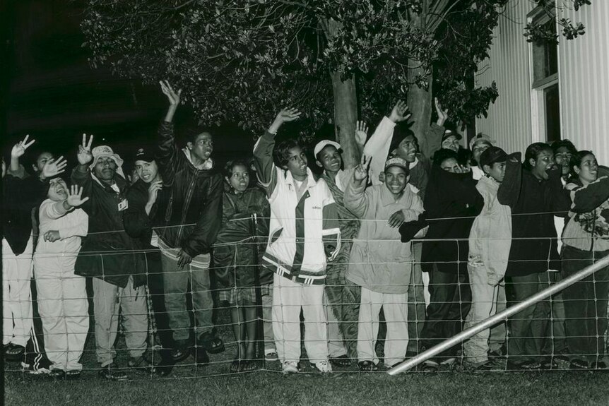 A crowd of East Timorese people wave at Puckapunyal Safe Haven, in 1999.