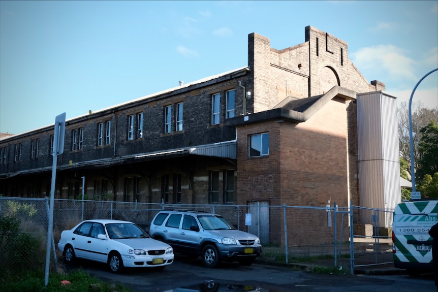 A brick building with a large fence surrounding it in North Eveleigh.