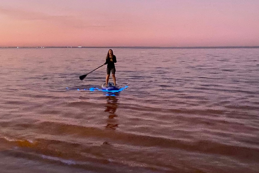 Olivia Berry paddles through bioluminescence at Queens Beach at Moreton Bay, off Brisbane.