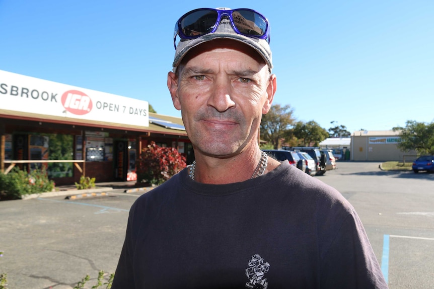 A tight head and shoulders shot of Bullsbrook resident Dean Dixon wearing a cap standing outside an IGA store.
