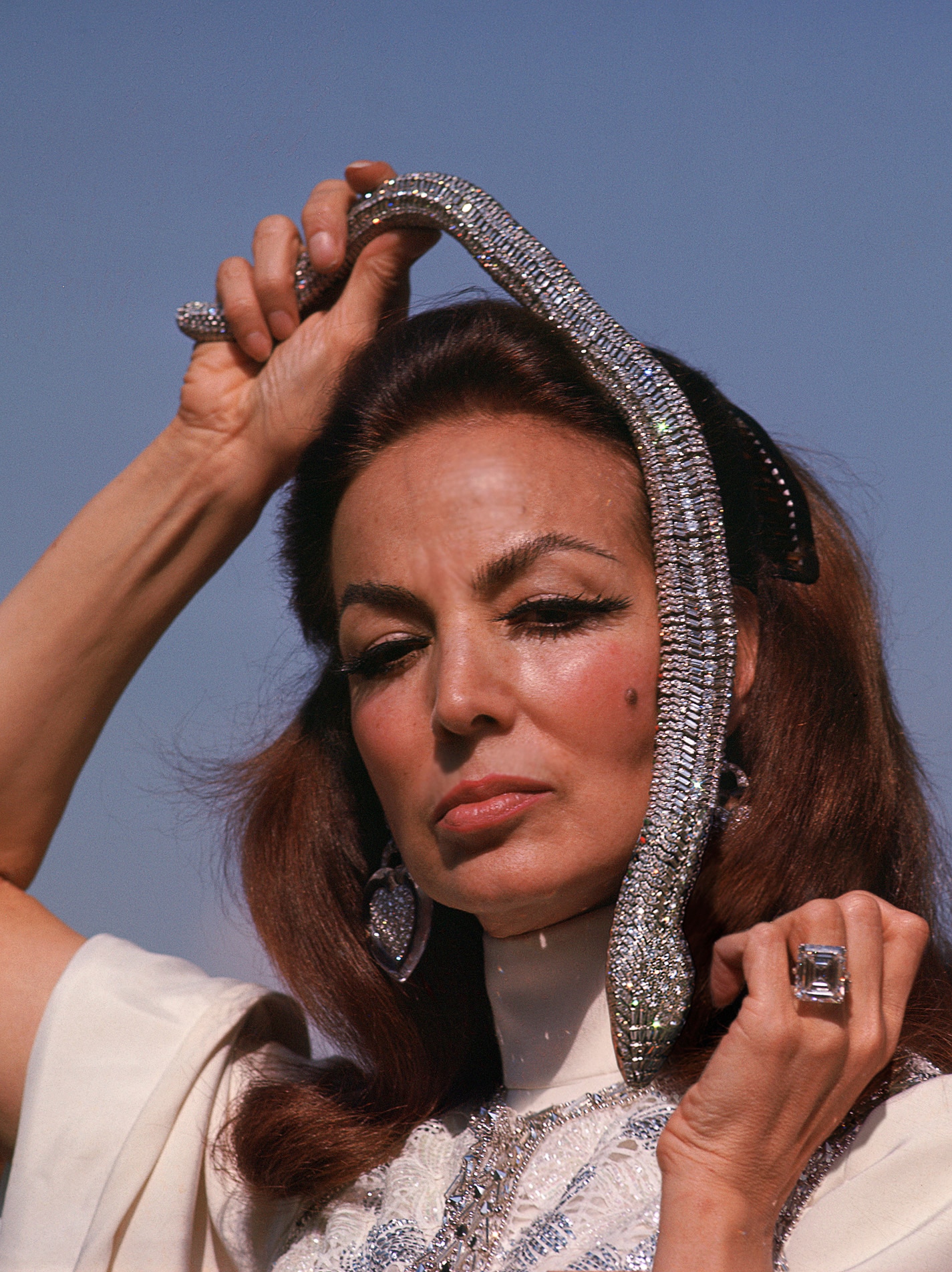 María Félix holding her snake Cartier necklace on her head