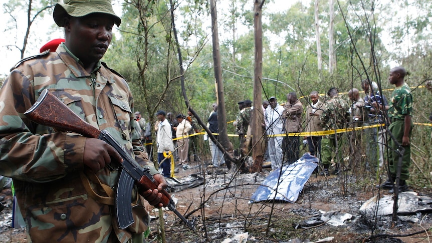 A policeman secures the scene of a helicopter crash at a forest in the Kibiko area of Ngong township.