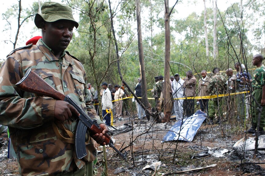 A policeman secures the scene of a helicopter crash at a forest in the Kibiko area of Ngong township.
