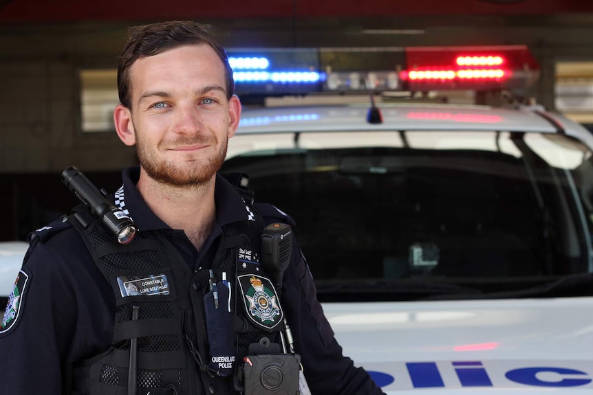 Police constable Luke Southgate leans on a police car