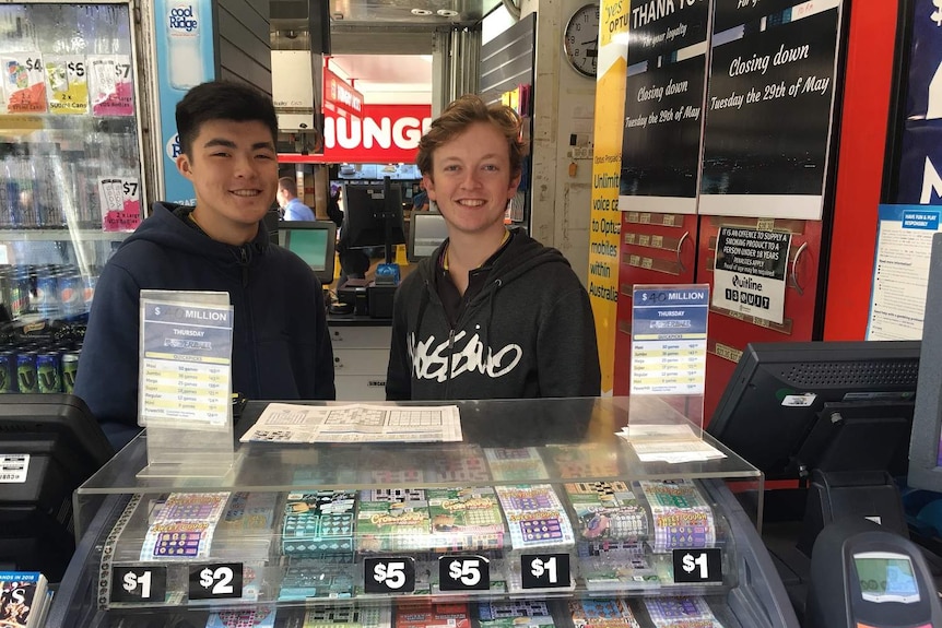 Two young men behind newsagency counter