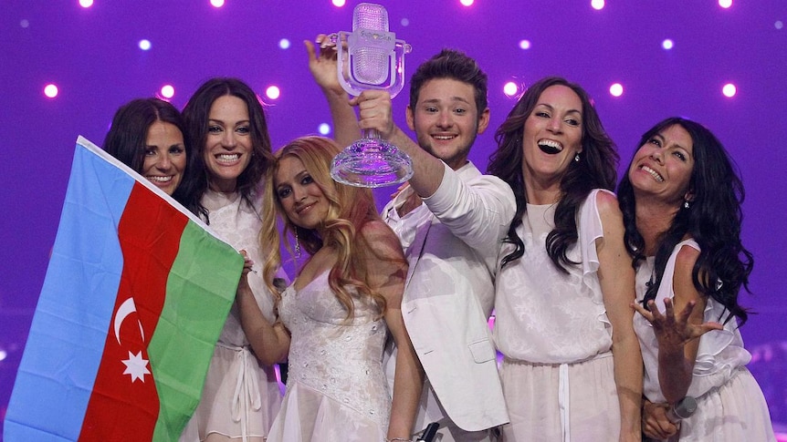Ell and Nikki (centre) pose with the Eurovision trophy.