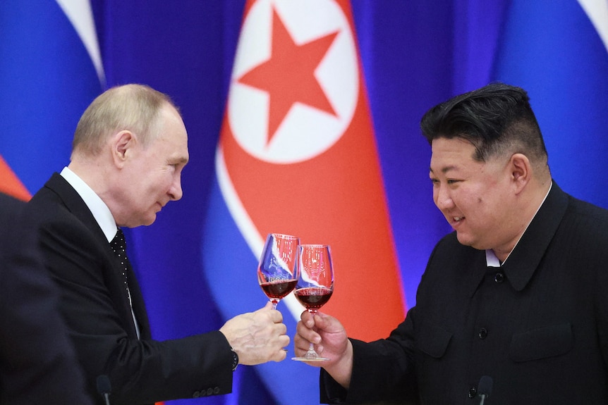 Putin and Kim Jong Un toast glasses of red wine 