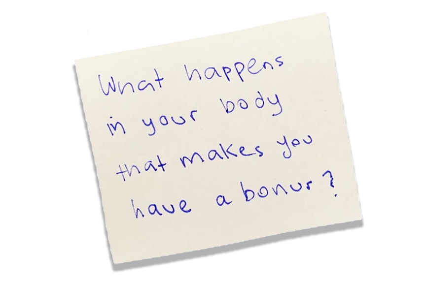 A white piece of paper with a handwritten question that reads: "What happens in your body that makes you have a bonur?"