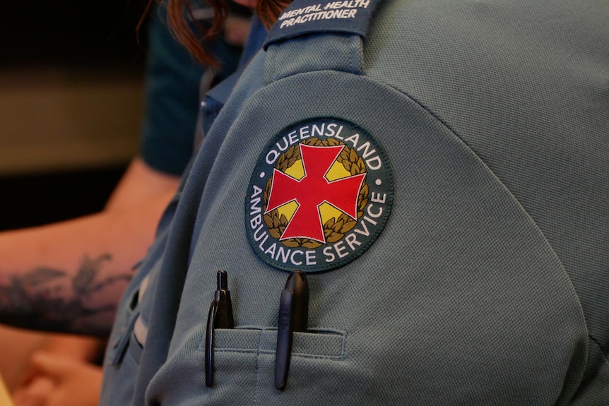A close up of a Queensland Ambulance Service label sewn on to the shoulder of shirt