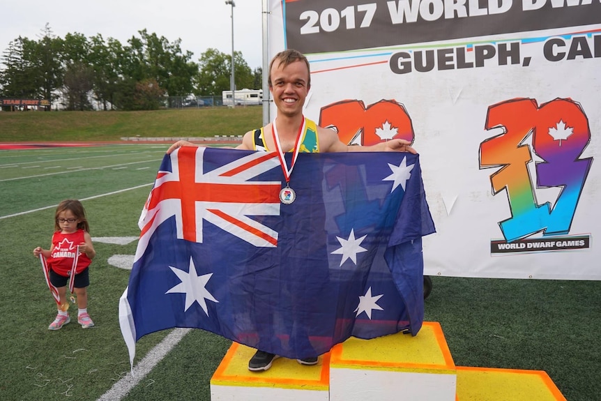 Luke Missen holds up the Australian flag.