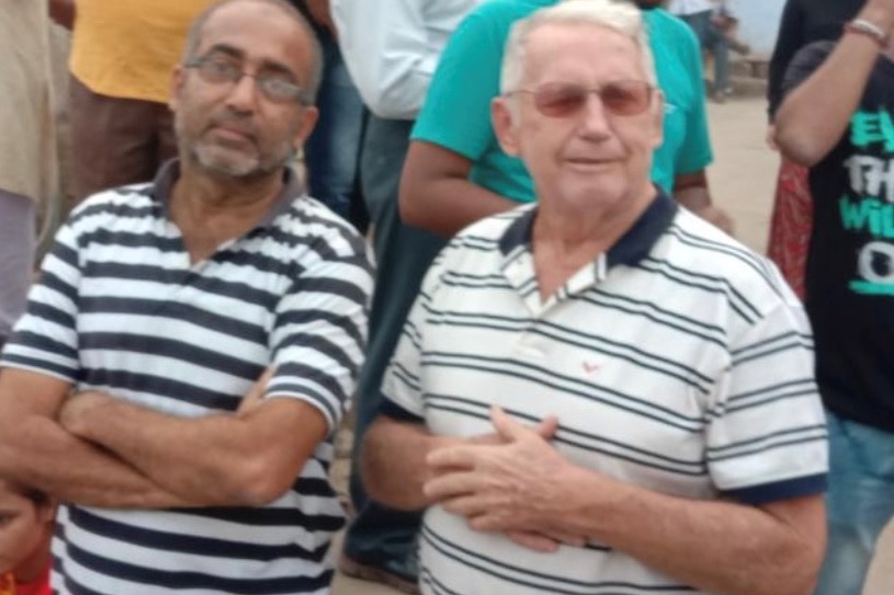 Two men in polo shirts pose for the camera.