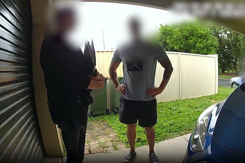 Police arresting a man on the Gold Coast. Both the officer and the alleged offender's face are blurred.