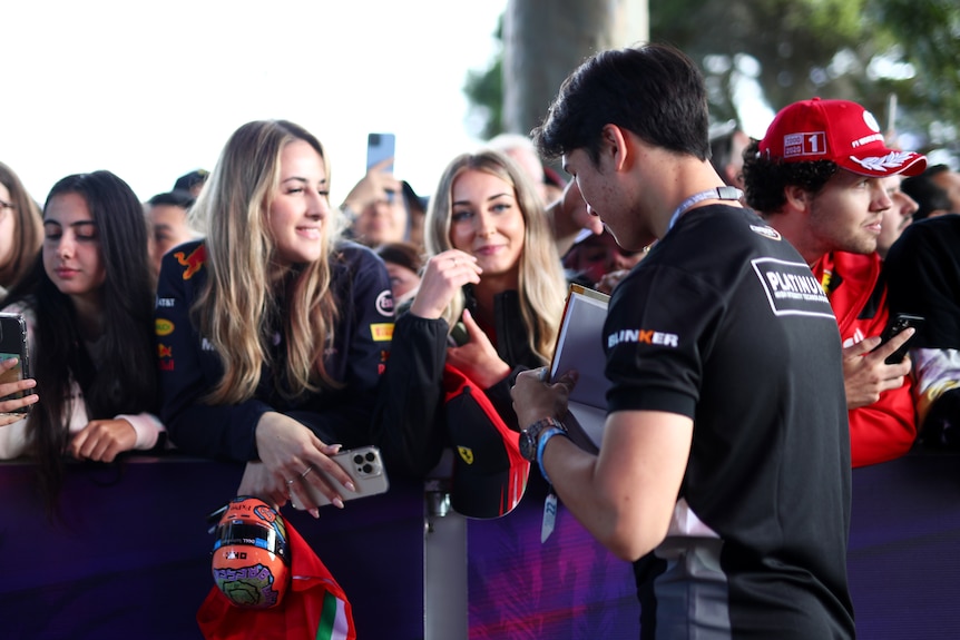 Female fans in the crowd hunt for autographs at the F1