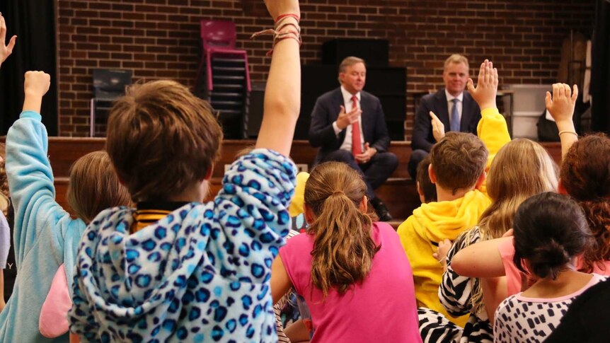 Kids putting their hands up to ask questions of Anthony Albanese and Tony Smith.
