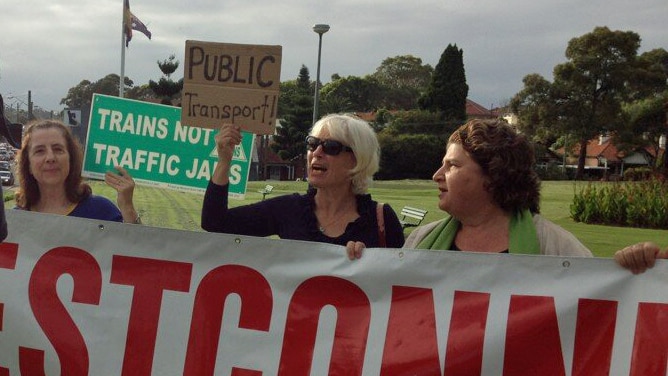 A small group of people protest against the planned west Connex motorway in Sydney
