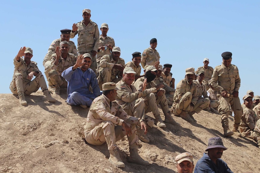 A group of soldiers smile and wave.