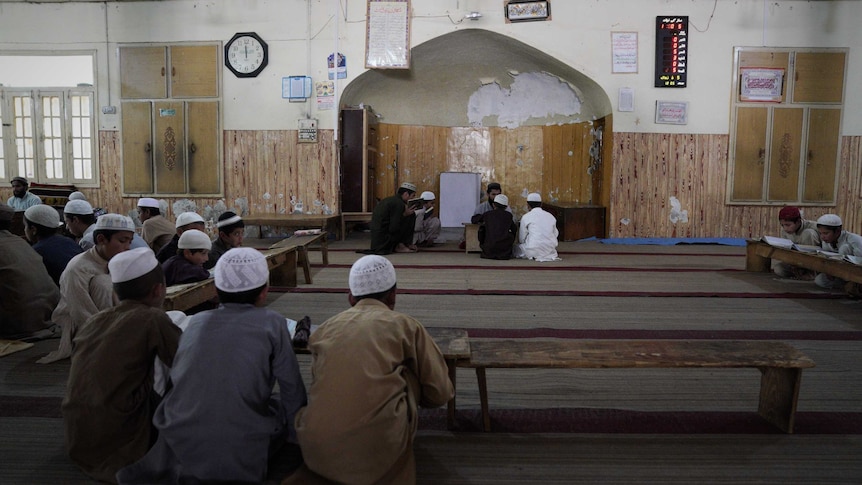 A room filled with boys studying the Koran