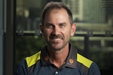 Justin Langer wears a blue and yellow shirt
