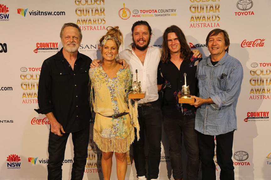 Kasey Chambers and the Fireside Disciples pose with their Guitar Guitars
