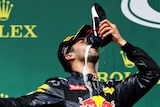 Daniel Ricciardo drinks champagne out of his boot after the German Grand Prix