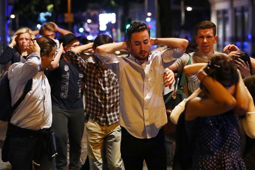 People leave the area with their hands up after an incident near London Bridge.