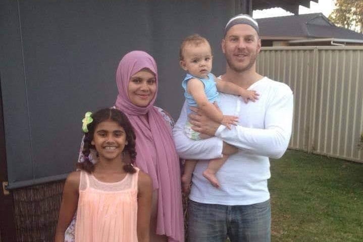 A family of four smiling.