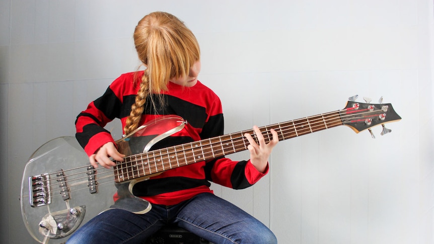 Young girl playing bass guitar