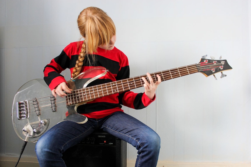 Young girl playing bass guitar