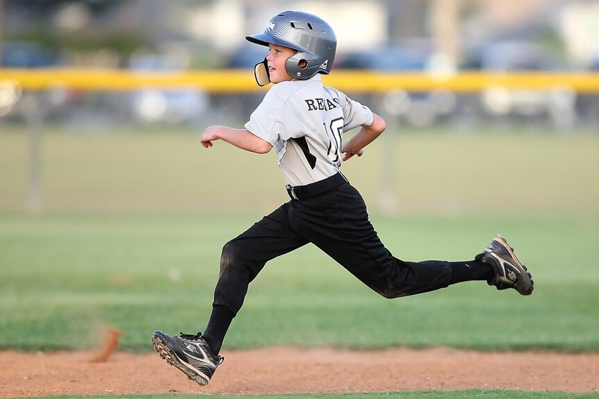 A child runs around a baseball diamond.