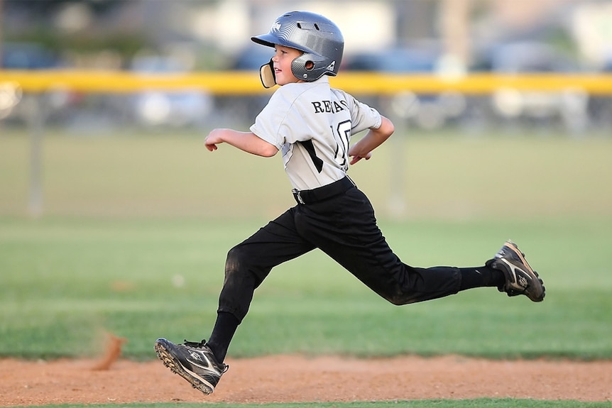 A child runs around a baseball diamond.