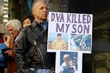 Ross Grant holds a sign outside the DVA that reads: "DVA killed my son"