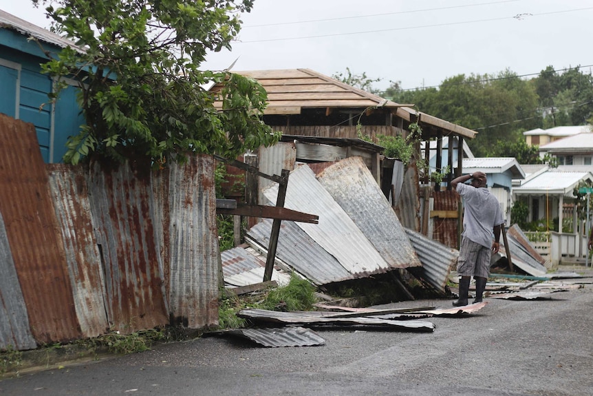 A man surveys the wreckage on his property after the passing of Hurricane Irma