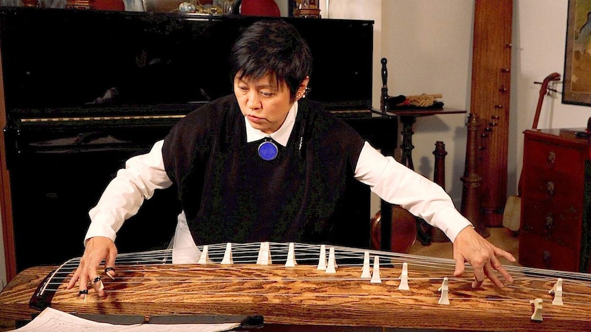A woman plays the Japanese koto, a large zither.