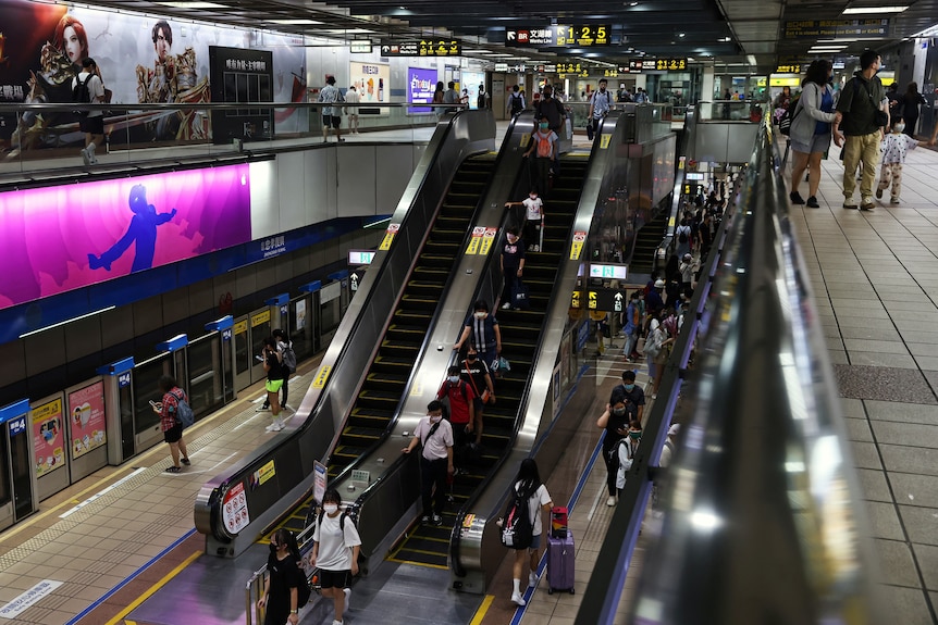 People use escalators in a underground metro station in Taiwan. 