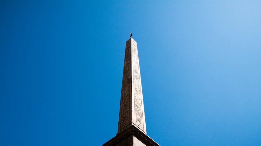 An Obelisk in front of a blue sky