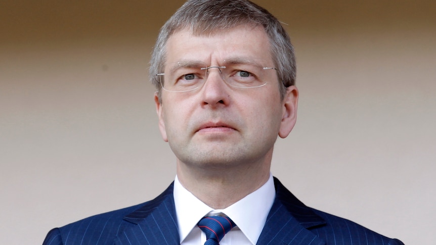 A headshot of Dmitry Rybolovelev wearing glasses and a navy suit jacket. 