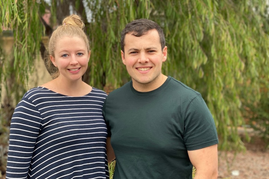 A woman and a man look at the camera.