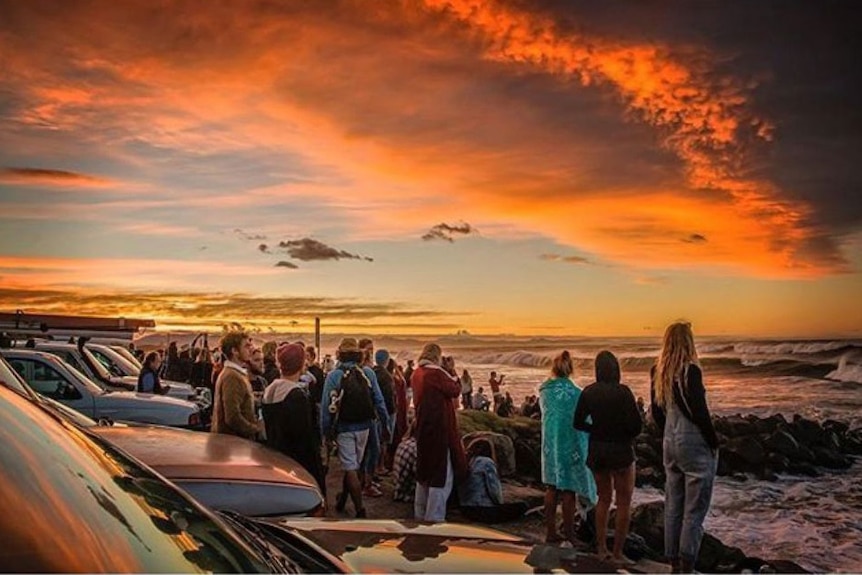Crowd watching surfers from Byron Bay car park