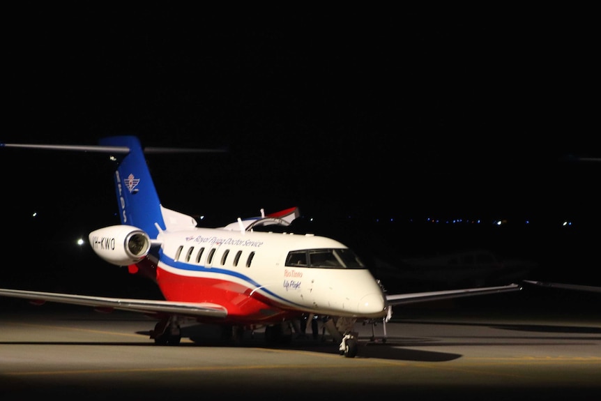 An RFDS plane on the tarmac at Perth airport at night.