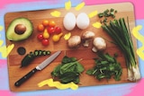 Ingredients on wooden chopping board including avocado, cherry tomatoes, eggs, mushrooms, and shallots