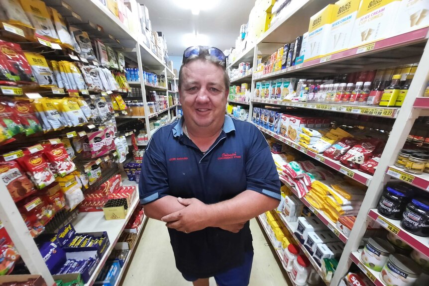 Man standing in supermarket aisle
