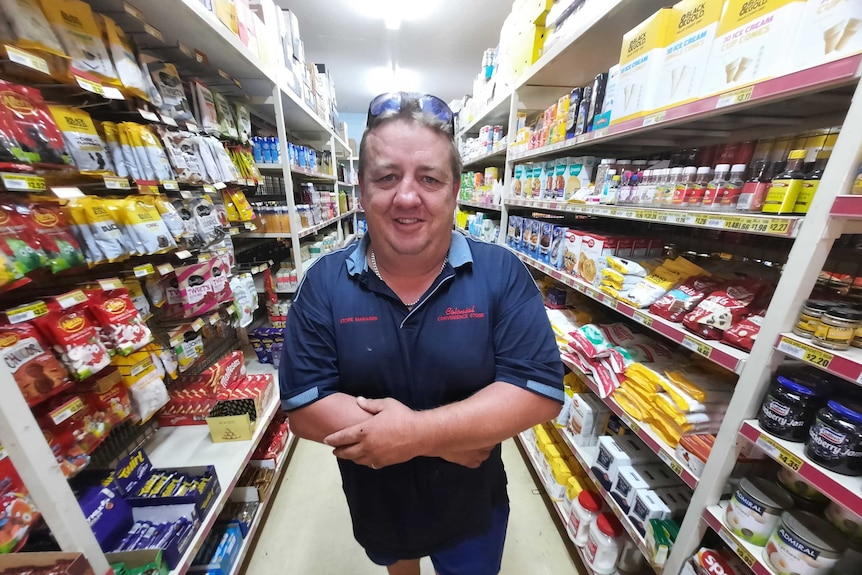 Man standing in supermarket aisle