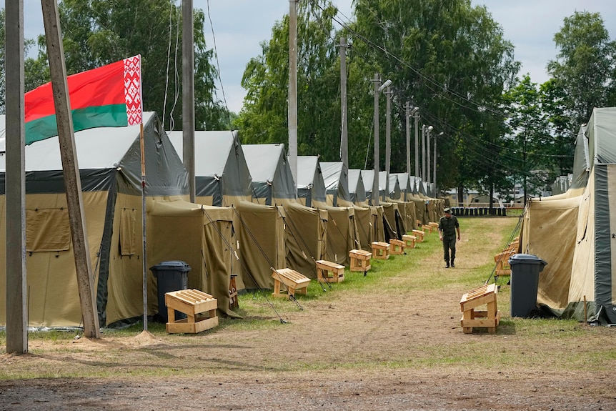 A row of army camps flying the Belarusian flag. 
