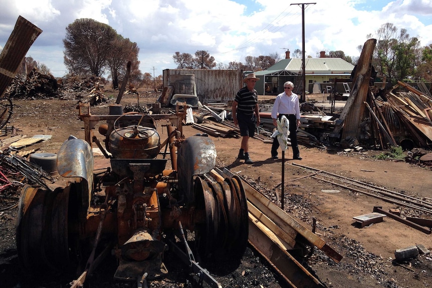 John Bubner walks with local recovery co-ordinator Vince Monerola showing the fire damage to his farm.