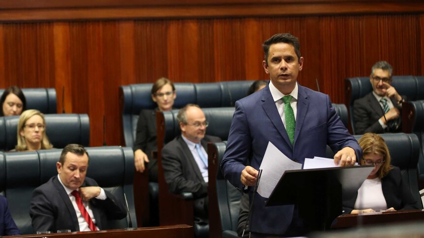 WA Treasurer Ben Wyatt speaking in the WA Parliament as Labor MPs sit behind him.