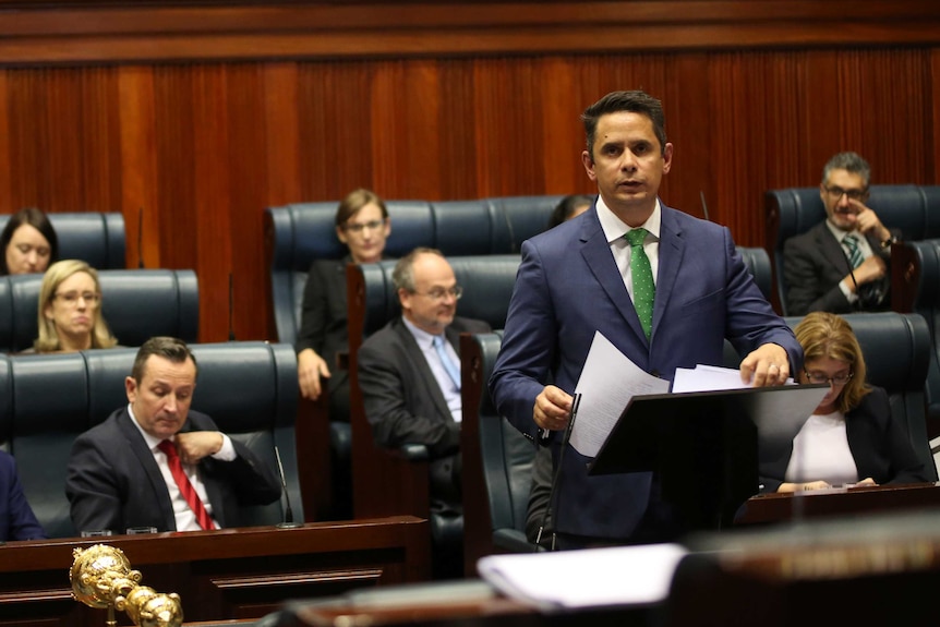 WA Treasurer Ben Wyatt speaking in the WA Parliament as Labor MPs sit behind him.