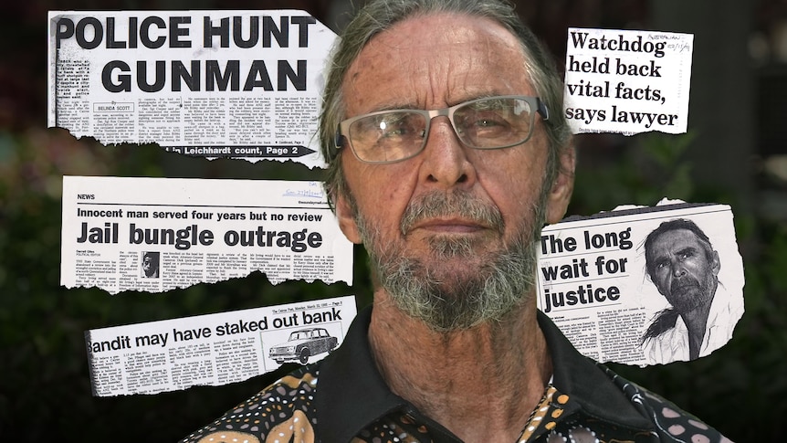An older Indigenous man with a backdrop of newspaper clippings from the early 90s.