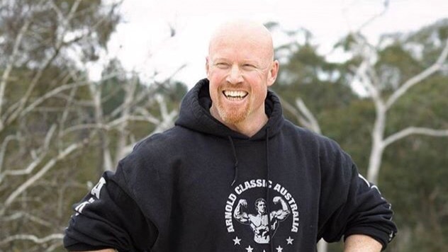 A bald man with a ginger beard in a hoodie.
